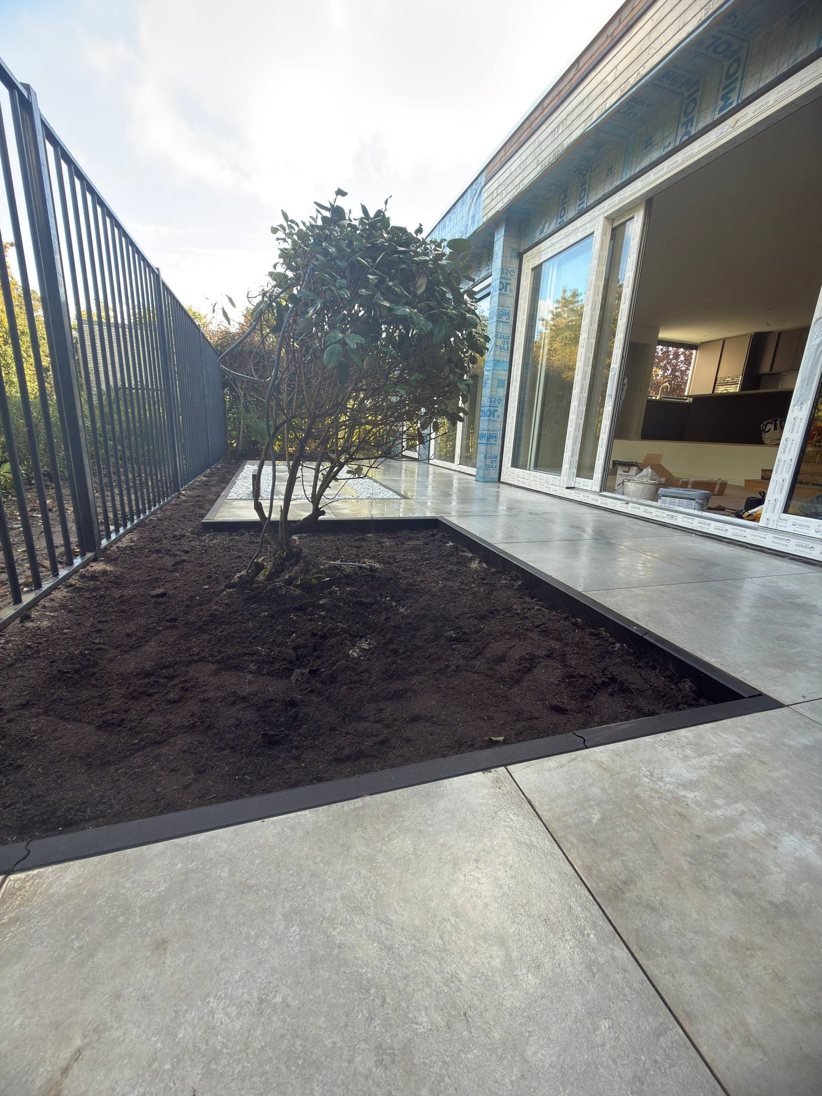 Nieuwe tuinborder langs het metalen hekwerk