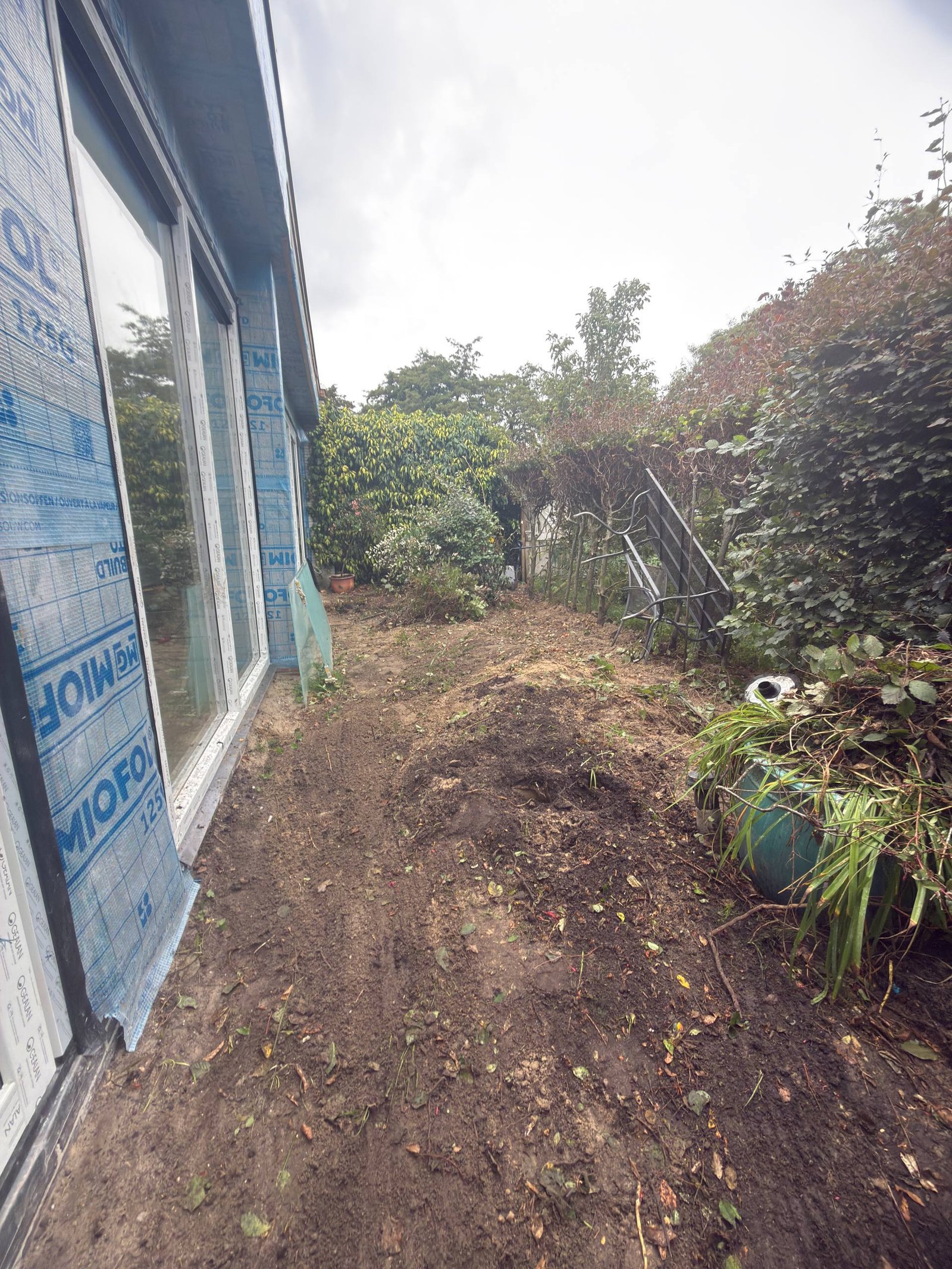 Vrijgemaakte strook langs de gevel tijdens de tuinrenovatie