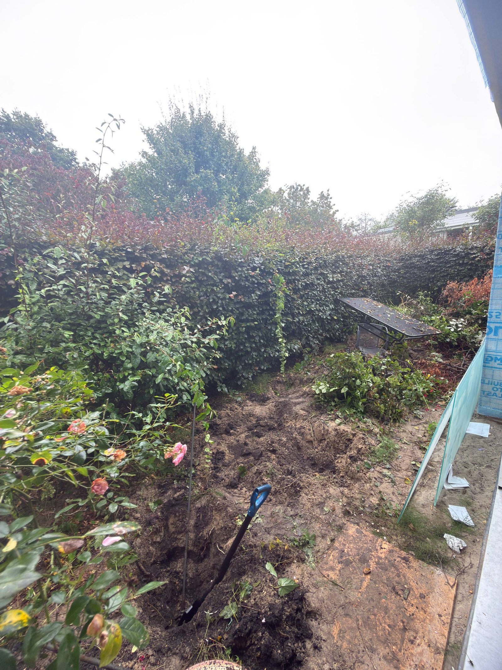 Bestaande beplanting en grond tijdens het opruimen van de tuin