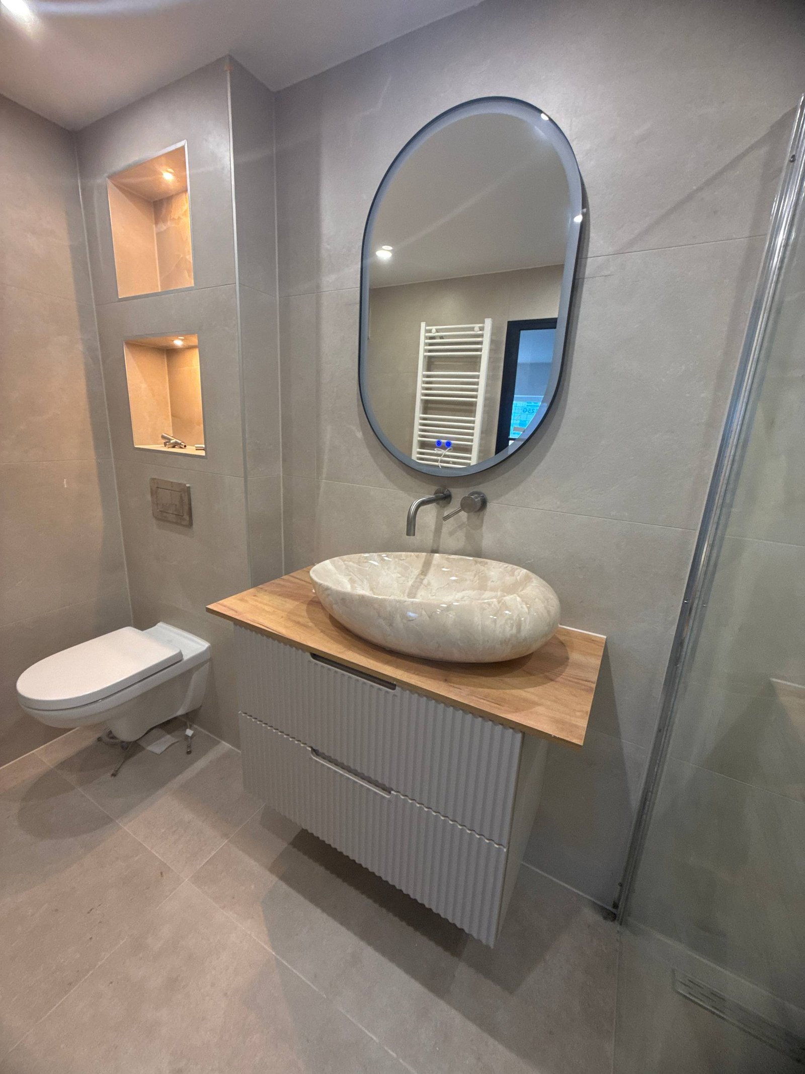 Wastafelmeubel en spiegel in de vernieuwde badkamer